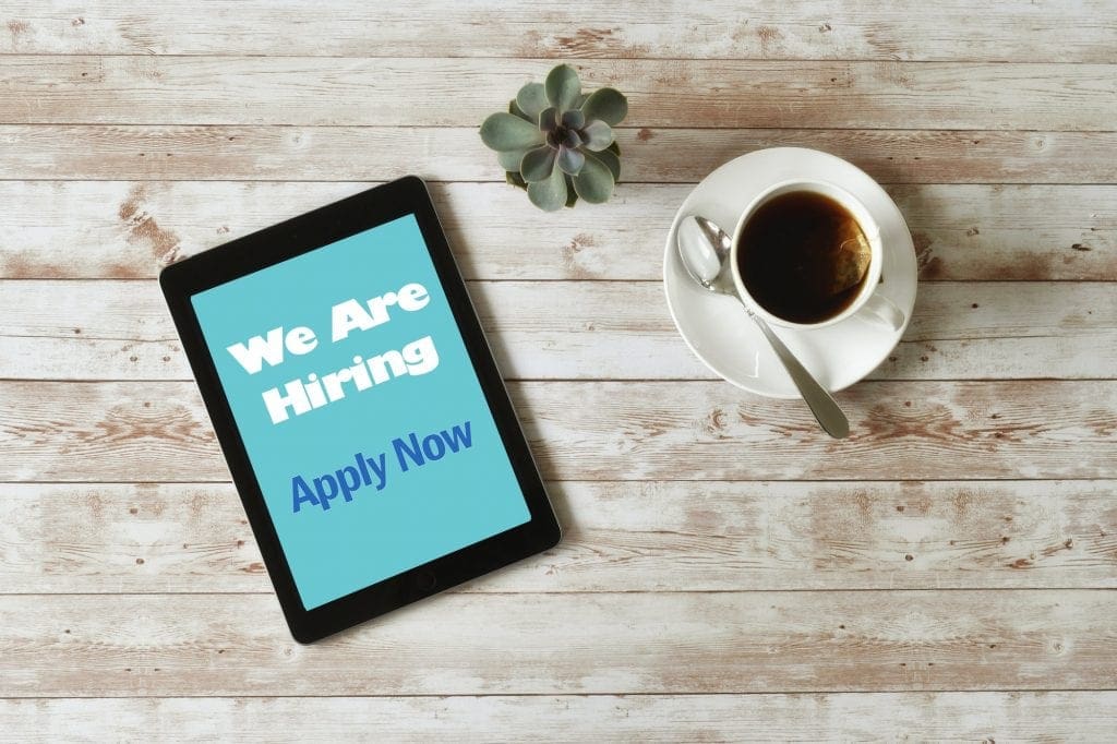 Online Job Search - We are Hiring Apply Now on tablet screen, minimal desk, overhead high angle iPad