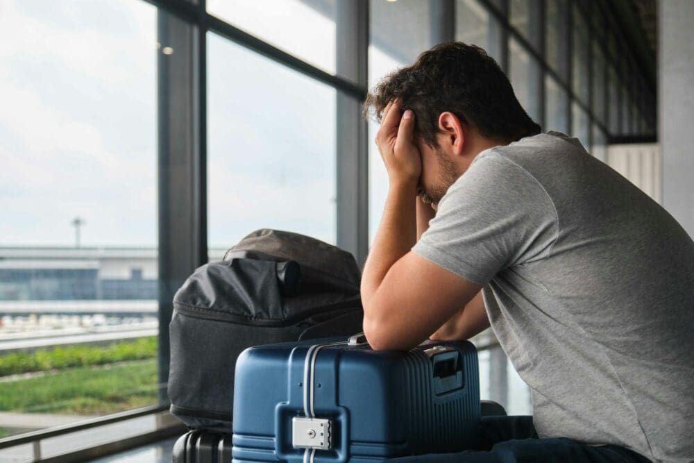 Man crying at the airport, frustrated because his flight was canceled.