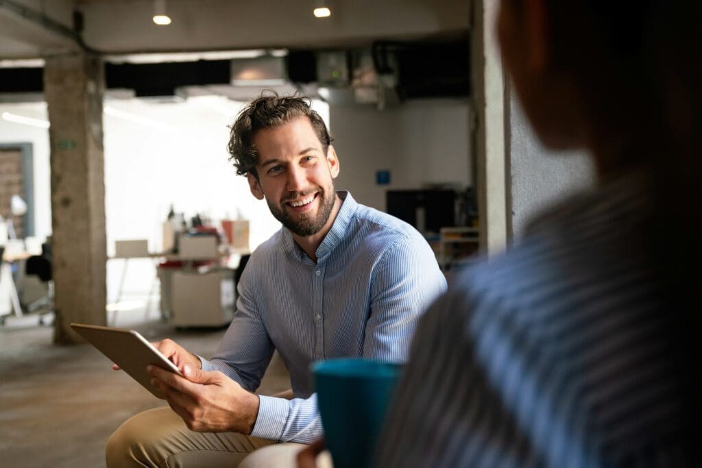 Portrait of successful handsome business man using digital tablet in office