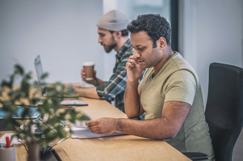 Two guys with laptop and smartphone working in office